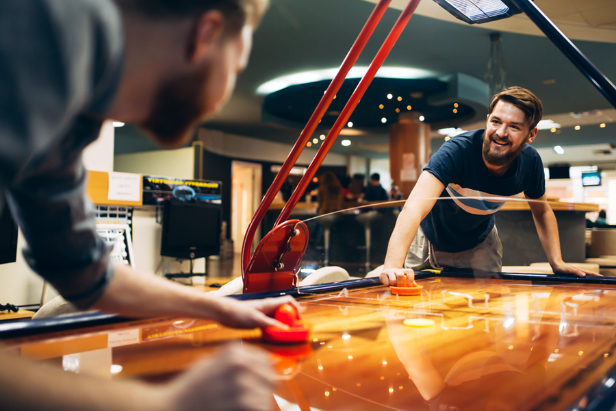 Colleagues Playing Air Hockey at an Arcade
